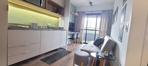 A compact kitchen with a dining area, a small table, and a sofa.