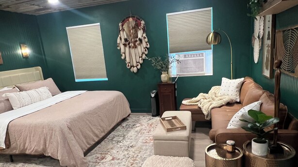 A bedroom with a bed, a sofa, a coffee table, and a decorative wall hanging. - Cozy farmhouse cabin near Kilgore and Longview (Longview)