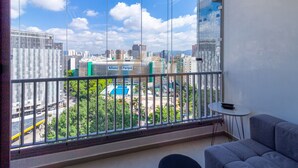 A balcony with a city view, a small table, and a sofa. - Apartamento/sp/perdizes/allianz/wi-fi 500mb/rooftop/piscina/vaga (Perdizes São Paulo)