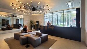 A modern lobby with a large seating area, a coffee station, and a reception desk. - Apartamento/sp/perdizes/allianz/wi-fi 500mb/rooftop/piscina/vaga (Perdizes São Paulo)