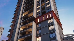 En høj bygning med flere altaner, store vinduer og et moderne arkitektonisk design.
