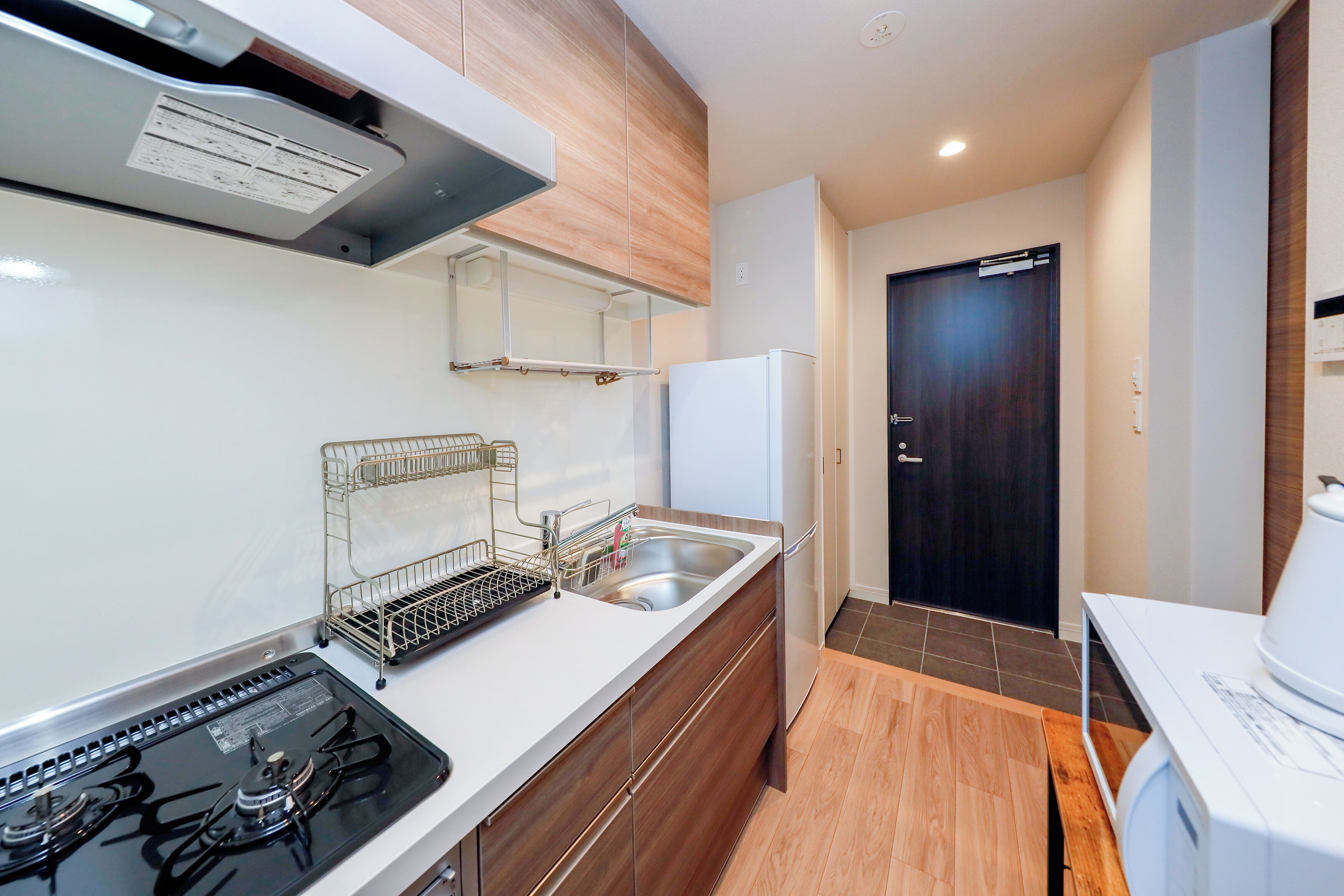 A modern kitchen with a gas stove, stainless steel sink, and a refrigerator.