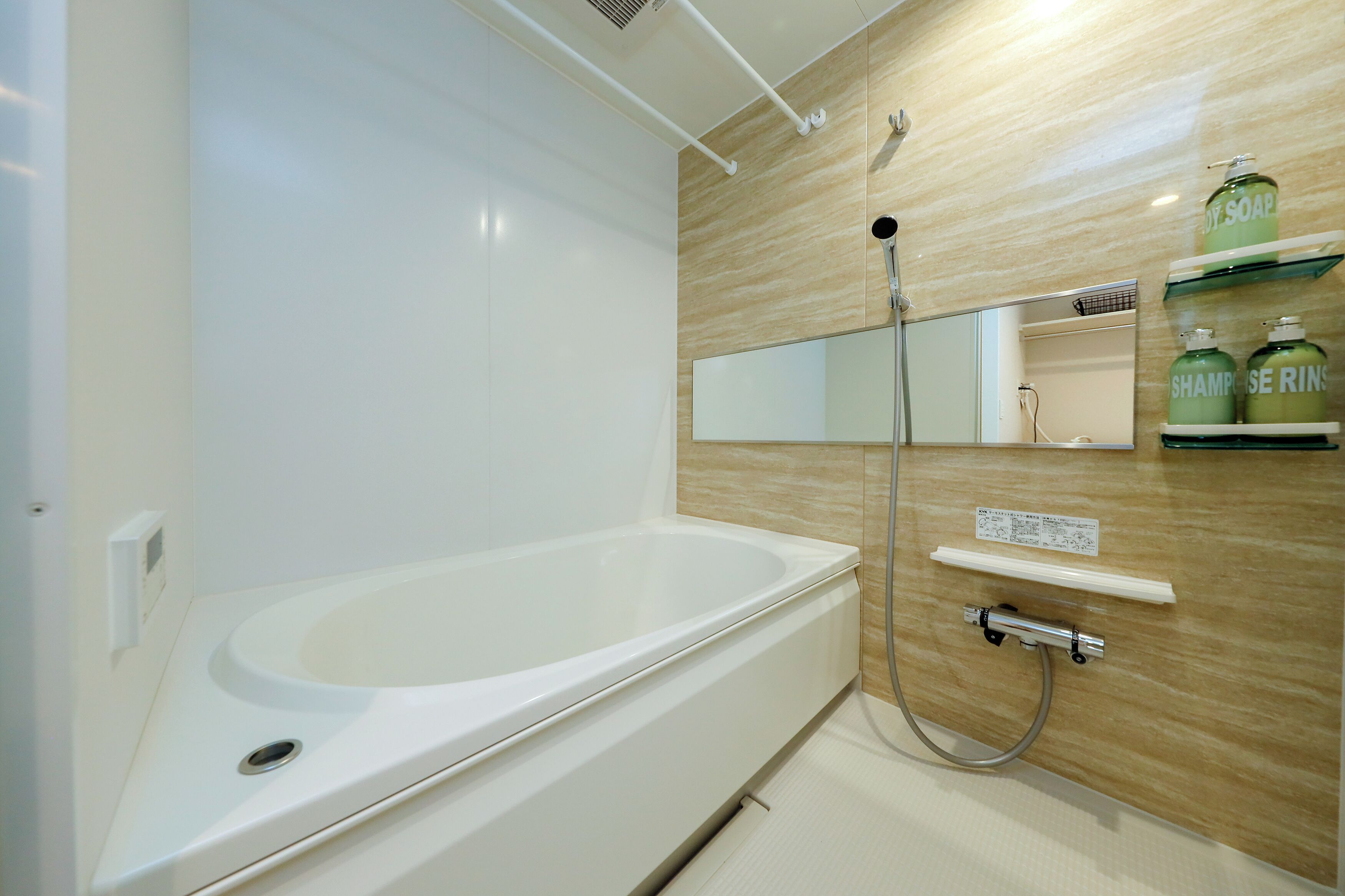 A modern bathroom with a bathtub, a shower, and a mirror.