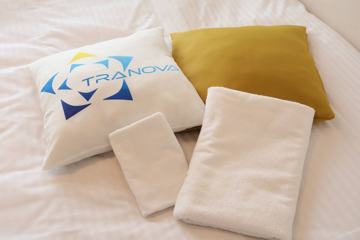 A bed with pillows and a folded towel.