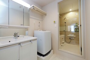 Bañera con ducha, secador de pelo, toallas, shampoo