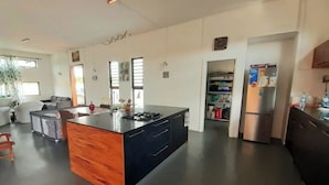 A modern kitchen with a central island, built-in appliances, and a dining area with a sofa and coffee table.