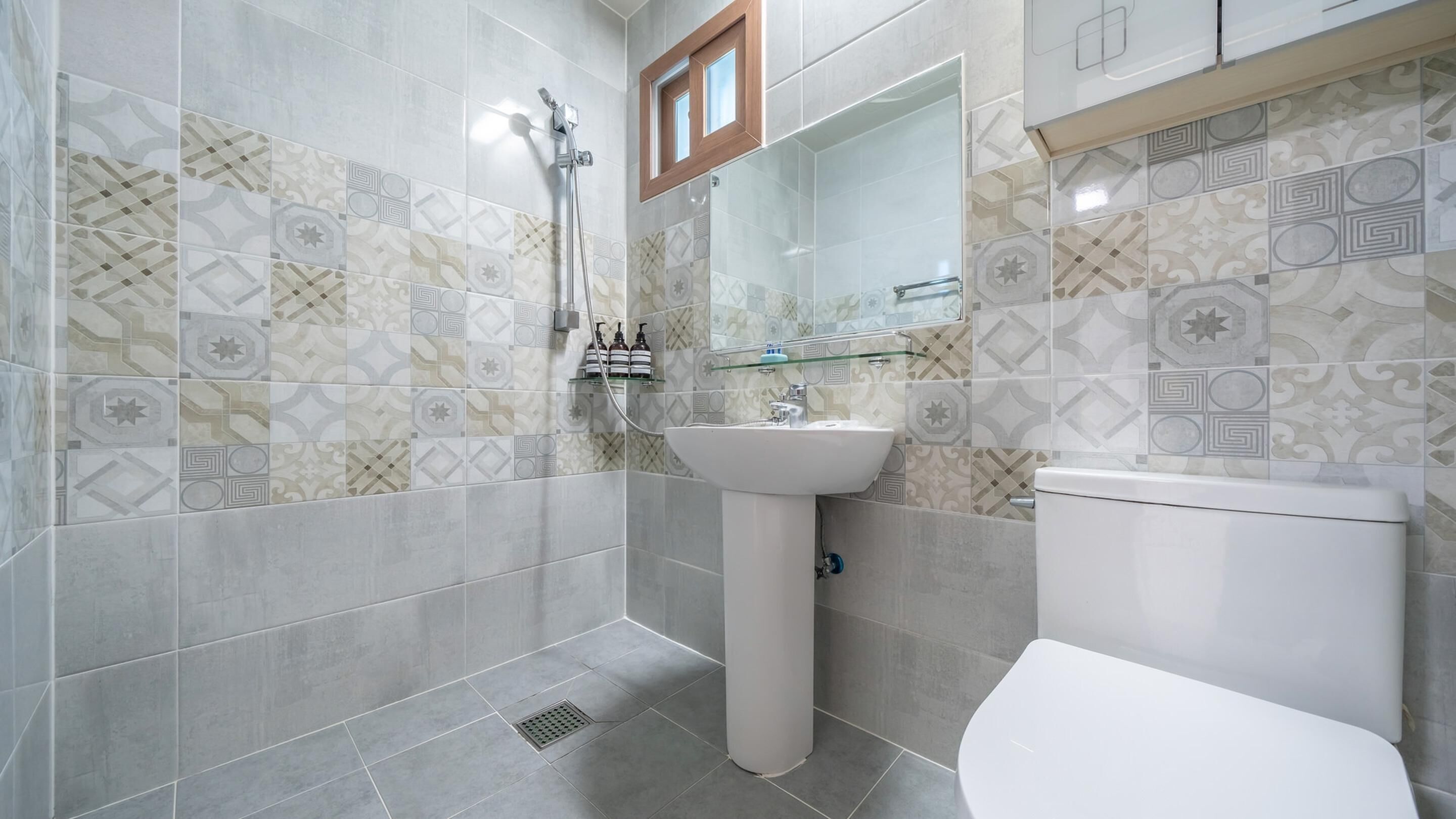 A bathroom with a shower, sink, and toilet.