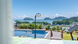 Ein Poolbereich mit Blick auf das Meer und die Hügel.