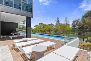 Relax by the pool surrounded by a serene landscape view.