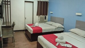 Une chambre d’hôtel avec deux lits, un bureau et une chaise.