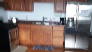 A kitchen with wooden cabinets, a stainless steel refrigerator, and a coffee maker.