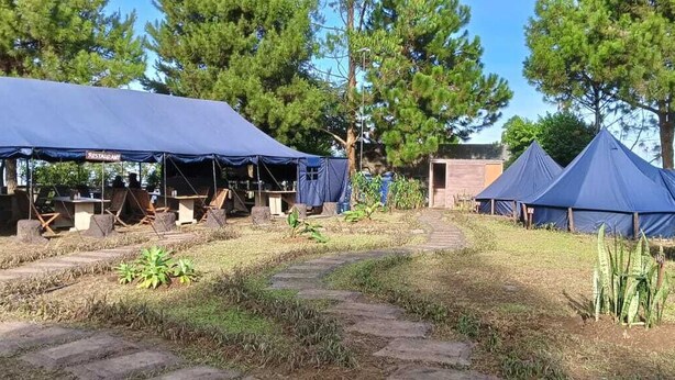 A campsite with several tents, a dining area, and a paved walkway. - Snow Princess Mountain Glamping Resort at Clubbali, Lembang (Lembang)