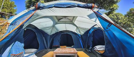 A dome-shaped tent with a central table and cushioned seating.