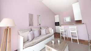 Una habitación acogedora con sofá, mesa de comedor y zona de cocina.