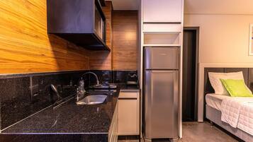 Una cocina compacta con refrigerador integrado, pileta y una mesada.