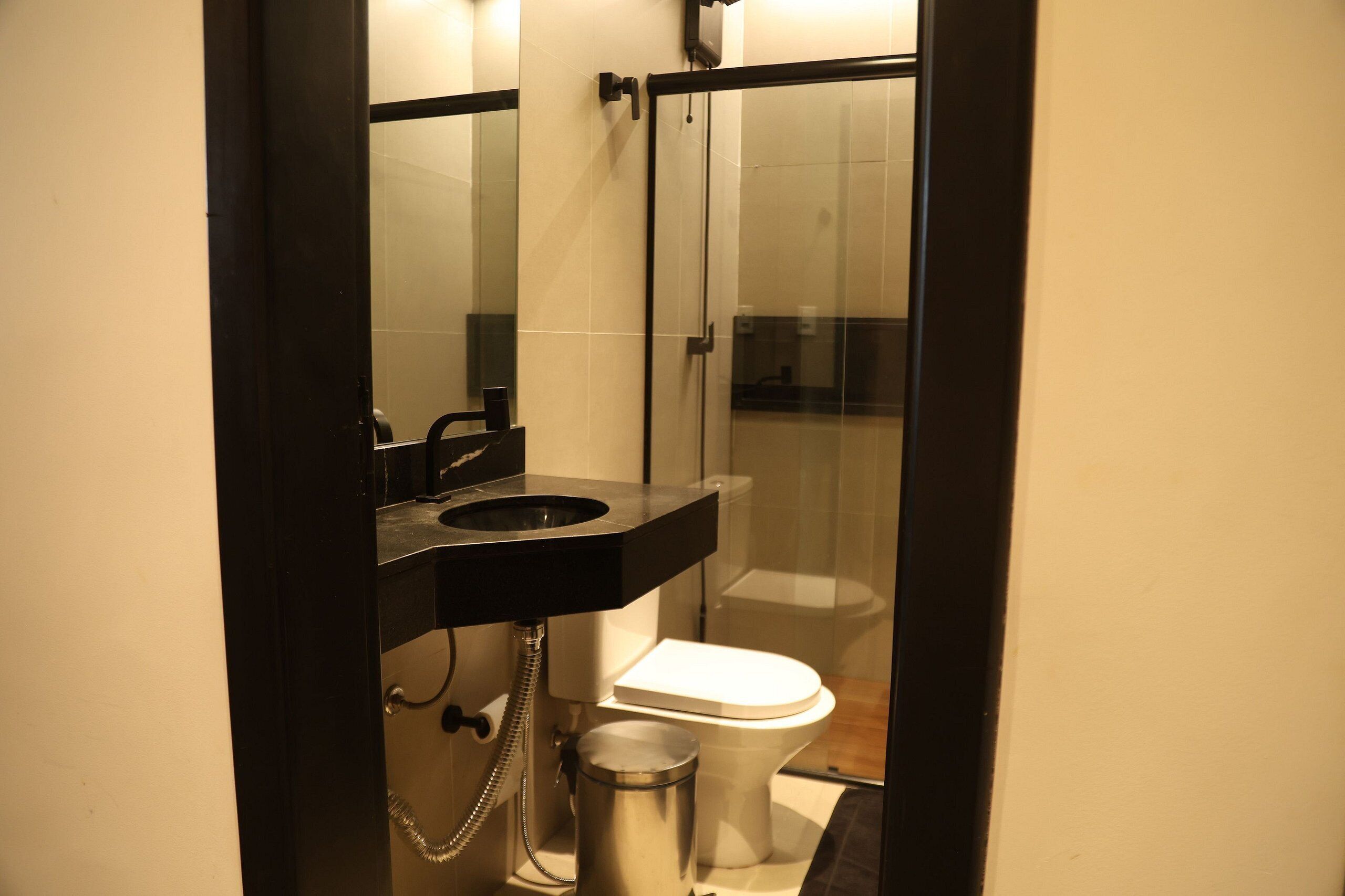 Un baño con inodoro, lavamanos y cabina de ducha.