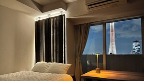 Hotellihuone, jossa on sänky, pöytä ja näkymä Eiffel-tornille.