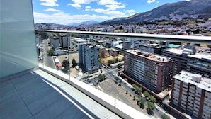 Varanda com vista para a cidade, incluindo edifícios e montanhas.