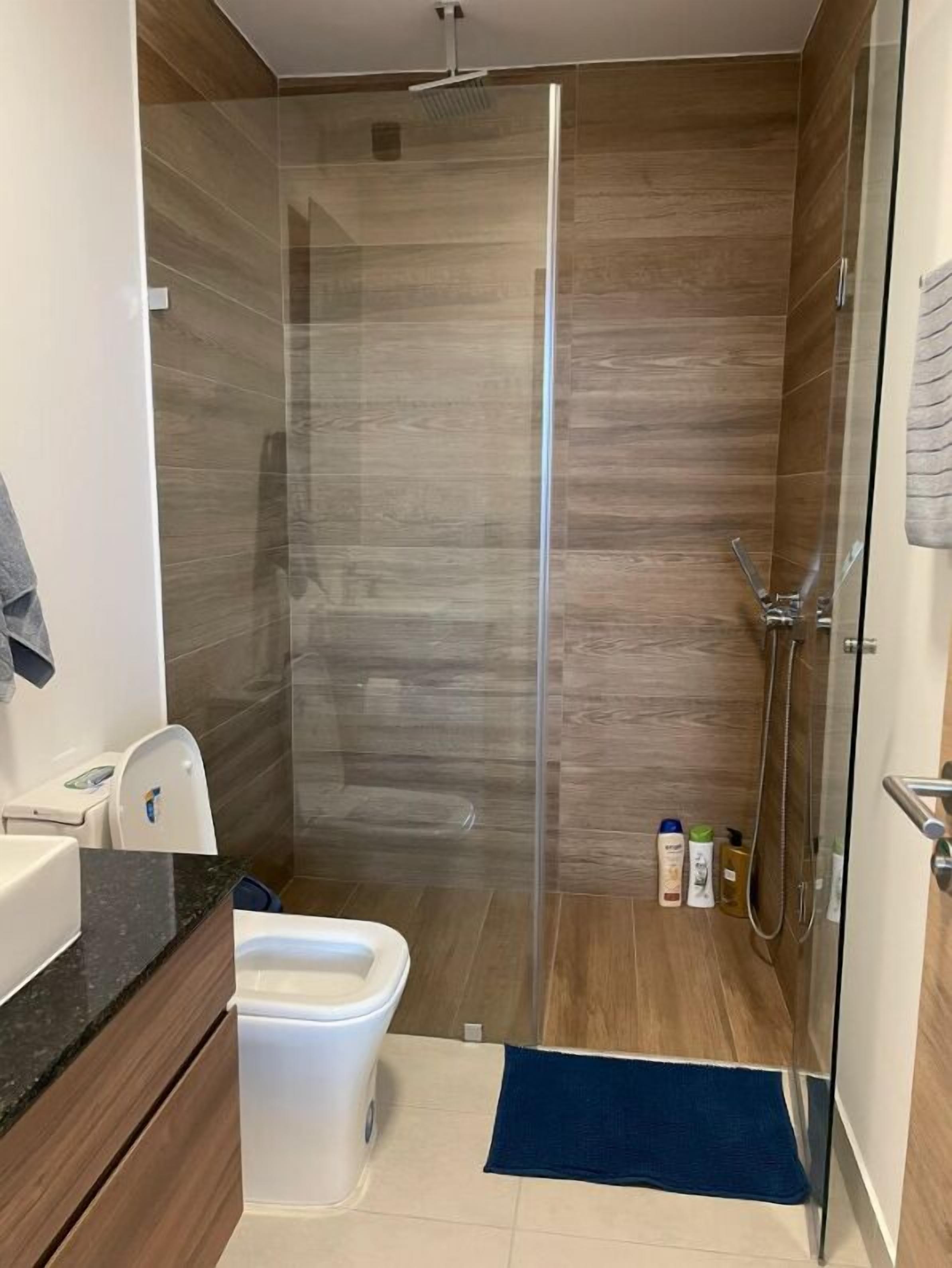 Une salle de bain moderne avec une douche à parois de verre, des toilettes et un lavabo.