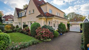 A two-story house with a paved driveway and a well-maintained garden. - Apartment 'Ferienwohnung Bleichen 14' with Shared Pool, Shared Garden and Wi-Fi (Stralsund)