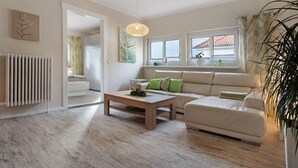 Moderni olohuone, jossa on sohva, sohvapöytä ja patteri.