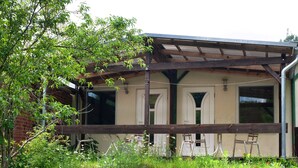 Een gebouw met een overdekte veranda, twee deuren en een raam.