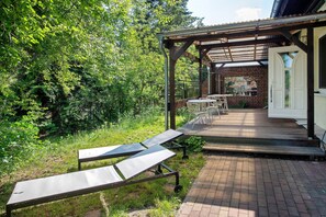 A covered outdoor seating area with a brick pathway leading to a building entrance. - Apartment 'Appartement 2' with Shared Terrace and Wi-Fi (Feldberger Seenlandschaft)