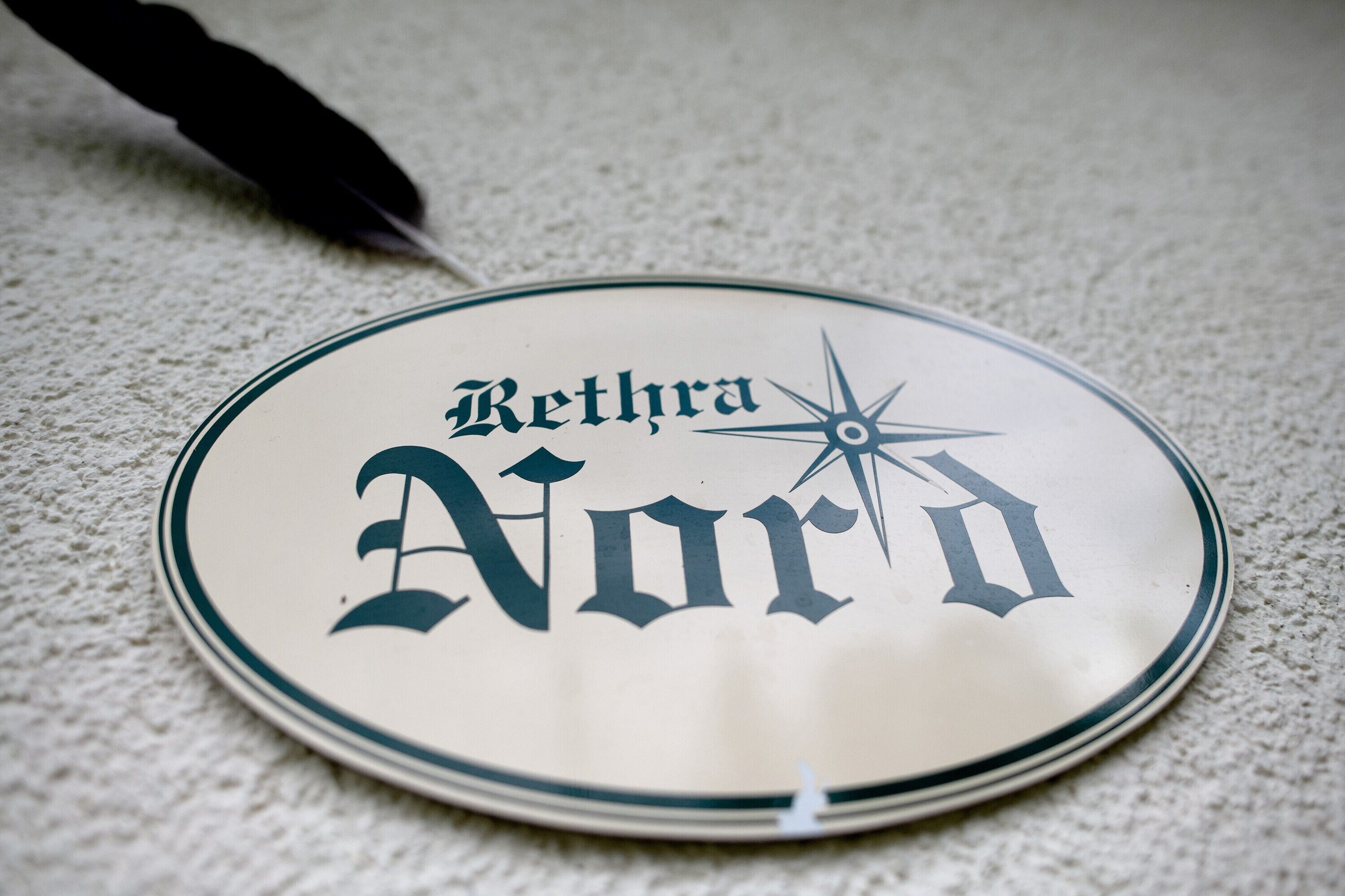 A round table with a plate that reads 'Rethra Nord' and a compass rose.