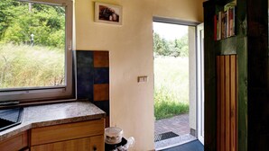 A kitchen with a window, a sink, a countertop, and a door leading outside. - Holiday home 'Rethra Nord' with private terrace and WLAN (Feldberger Seenlandschaft)