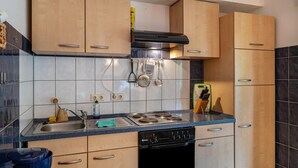 A kitchen with wooden cabinets, a stove, and a dishwasher.
