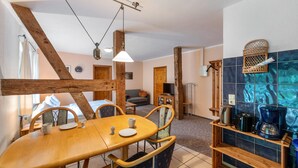 Une pièce chaleureuse avec une table à manger en bois, des chaises, un canapé et un coin café.