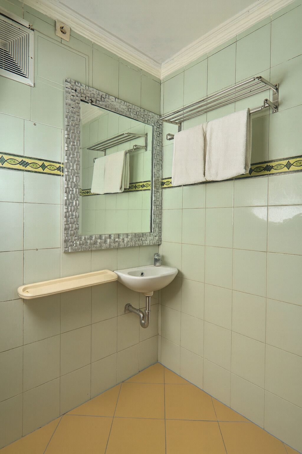 A bathroom with a sink, mirror, and towel rack.