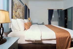 Une chambre d’hôtel avec un lit, une table de chevet, une lampe, un tableau au mur et une porte avec des rideaux.