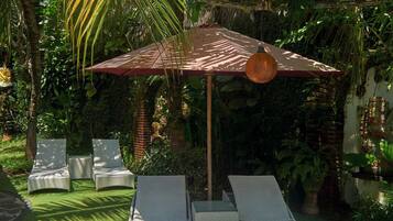 A garden with a seating area, a pergola, and lush greenery.