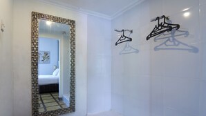 Une salle de bain avec un grand miroir, un porte-serviettes et des toilettes.