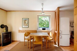 Une cuisine compacte comprenant une table à manger, des chaises, une cuisinière, une fenêtre avec vue et un réfrigérateur.