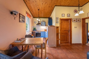 Une cuisine avec des meubles de rangement en bois, une table à manger et des chaises.