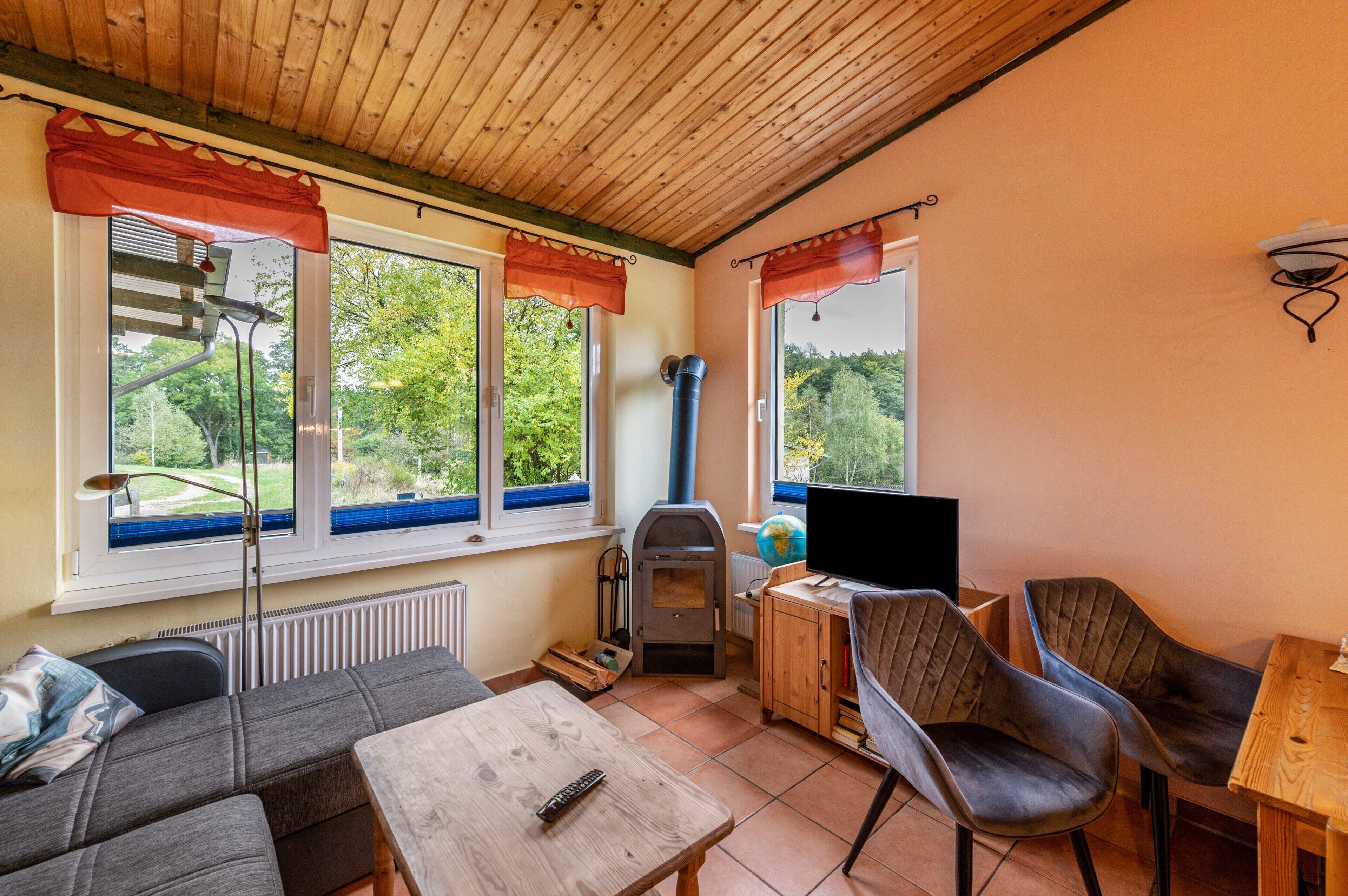Ein gemütliches Zimmer mit einer Couch, einem Holztisch, einem Fernseher und einem Kamin.