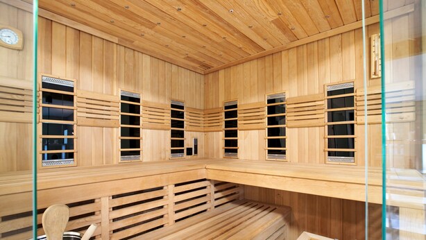 A sauna with wooden slats, benches, and ventilation windows.
