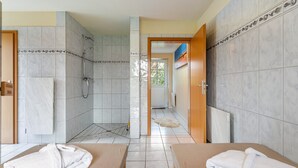 Ein Hotelzimmer mit zwei Betten, einer Dusche und Blick ins Freie.