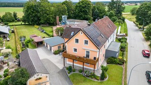 En boligejendom med et stort hus, en garage og en indkørsel.