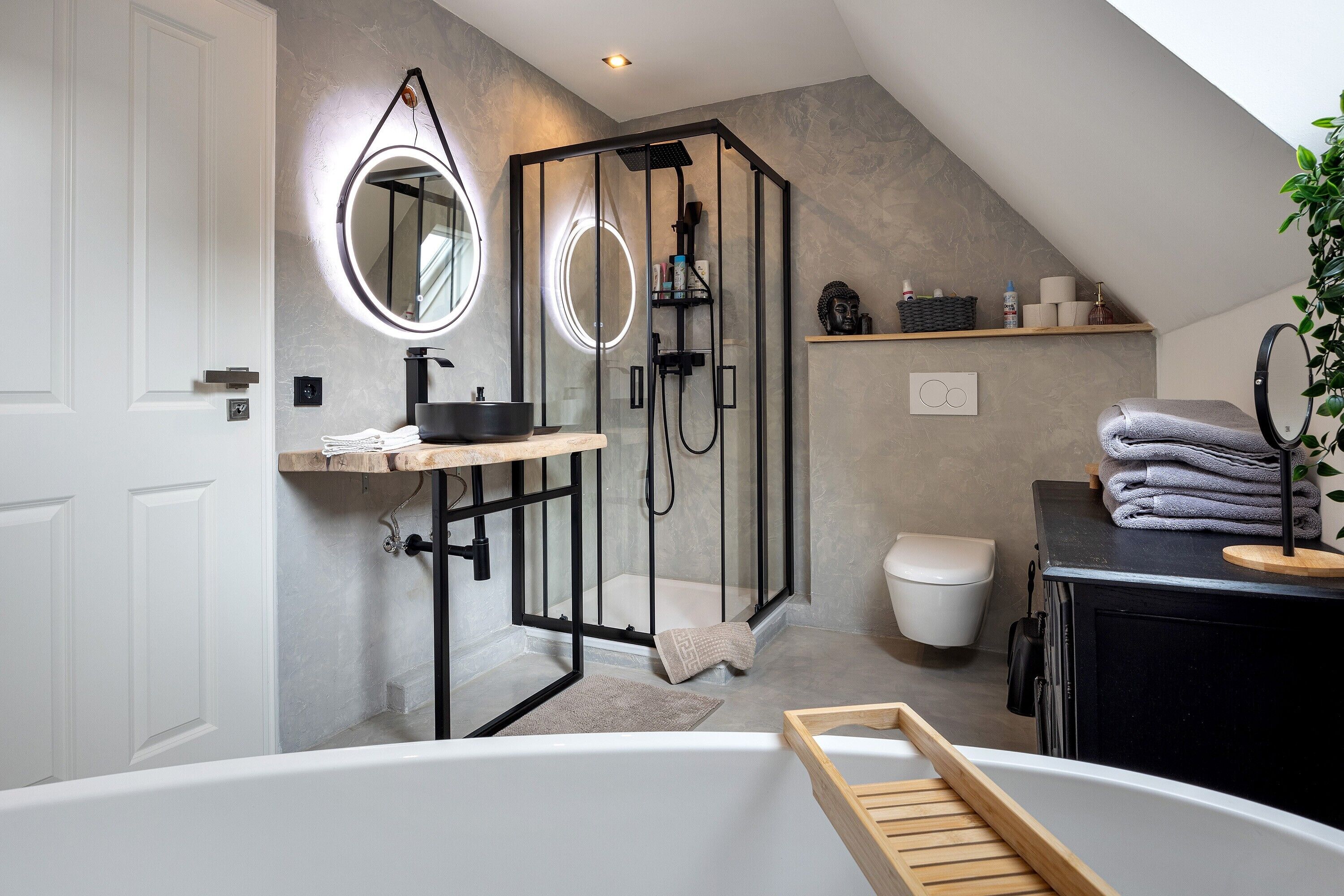 A modern bathroom with a freestanding bathtub, a glass-enclosed shower, and a vanity with a mirror.