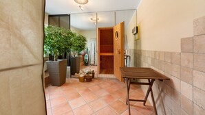 A hallway with a wooden bench, potted plants, and a wooden door leading to a room. - Apartment 'Rheinblick Am Rheinsteig' with Mountain View, Wi-Fi and Air Conditioning (Urbar)