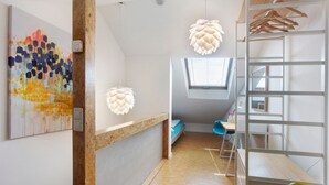 Une chambre avec un lit superposé, un bureau, une chaise et une fenêtre.