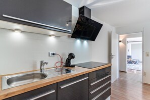 A modern kitchen with a built-in microwave, a sink, and a coffee machine. - Apartment 'Ferienwohnung Schwarzwaldmädel' with Private Terrace, Private Garden and Wi-Fi (Seelbach)