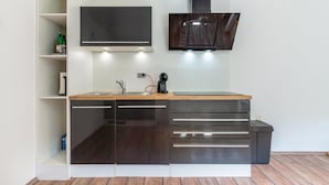 A modern kitchen with a built-in dishwasher, a coffee maker, and a microwave.