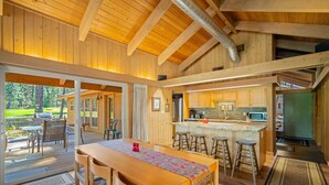 Una cocina amplia con una isla central, vigas de madera y vistas al exterior.