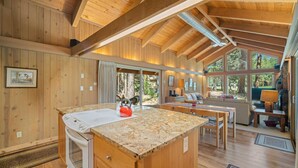 Una cocina amplia con encimera de granito, armarios de madera y horno empotrado.