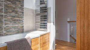 Une salle de bain moderne avec un meuble-lavabo en bois, un grand miroir et une cabine de douche en verre.