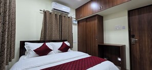 Een hotelkamer met een bed, een kledingkast en een airconditioning.